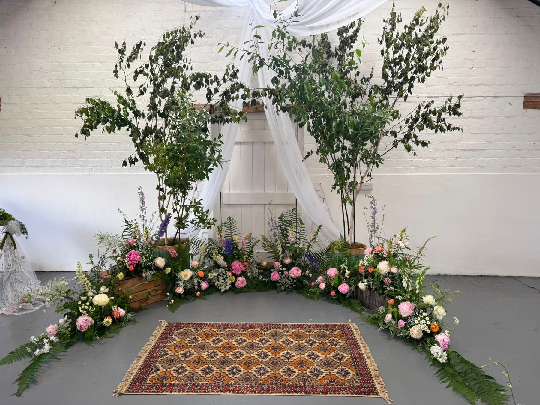 A lush birch-and-bloom wedding ceremony backdrop by Floralibus